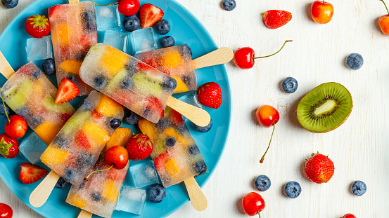 Homemade popsicles with berries and fruits, top view.