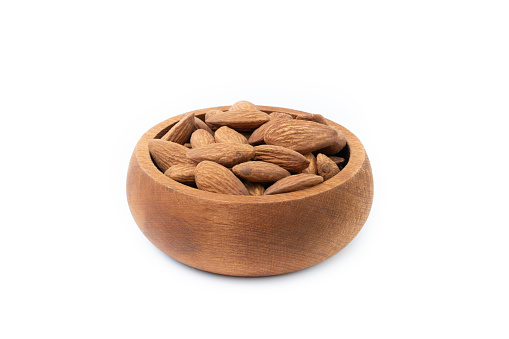 Dry Roasted Almonds in wooden bowl isolated on white background.