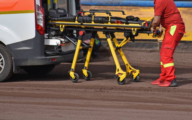 A medic pulls out the stretcher from the ambulance at the speedway track after a crush