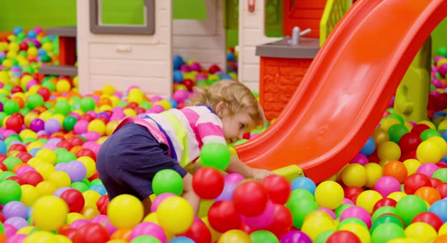 Toddler Sliding Down in Colorful Playroom