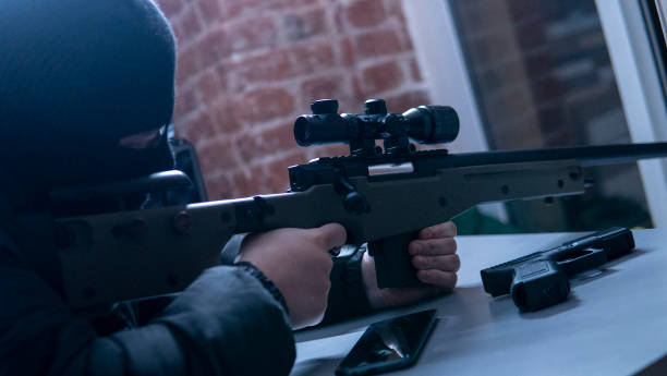 istock A sniper rifle is being aimed by a masked criminal 2106100279