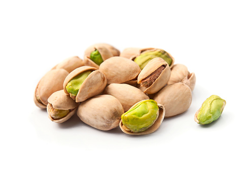 Pistachio nuts with leaves on white backgrounds