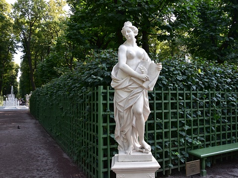 The impressive sculpture symbolizes the unification of Geneva with Switzerland in 1814.\nTwo women in bronze attire – the Republic of Geneva and Helvetias – holding each other entwined at the waist. Perched on their pedestal, they look north towards Switzerland.\n\nThe National Monument is located in the Jardin Anglais, facing the lake. It was inaugurated in 1869. With this work, the sculptor Robert Dorer symbolised Geneva’s integration into the Swiss Confederation on 12 September 1814 with two women each carrying a sword and shield.