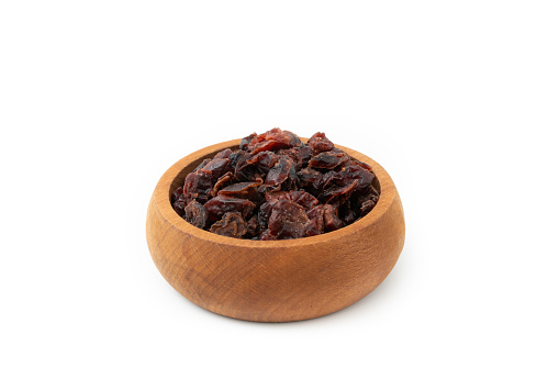 Dried berry fruits. Dried blueberries in wooden bowl isolated on white background.