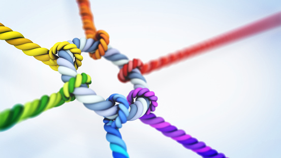 Vibrant Multi-Colored Ropes Tied Together in Intricate Knots Against a White Background. Teamwork and collaboration concept.