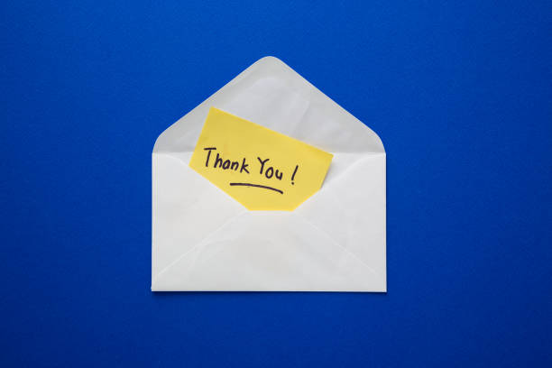 istock Thank you note on yellow paper in an envelope. 2106146858