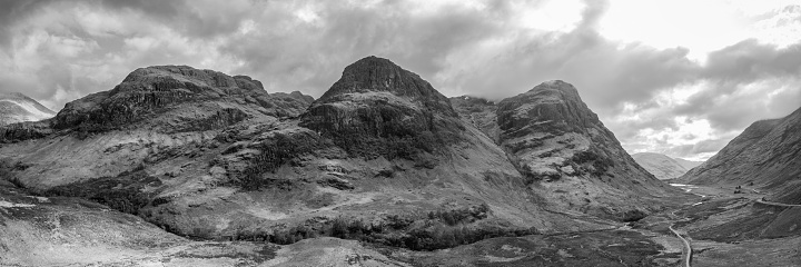 This super panorama unveils the Three Sisters majestic contours from a drone perspective, with the sweeping Glen Coe valley unfolding beneath a dramatic Scottish sky