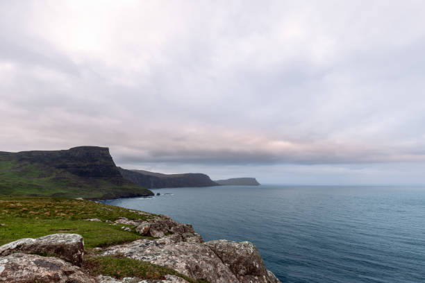A sweeping view of the cliffs of the Isle of Skye, under a brooding sky, overlooking the Atlantic Ocean