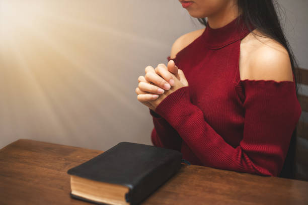 istock A woman sitting and praying to God. 2106158908