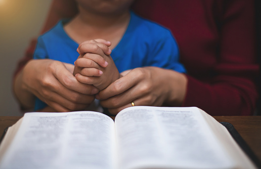 A mother is training her little child to pray. And she reads the Bible to her children before bed every night.