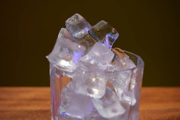 istock Ice cubes in a glass on a wooden table against a dark background 2106162064