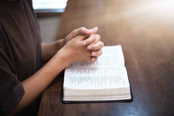 istock young woman sitting and praying. 2106164696