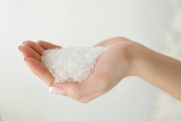 Pure white crystals salt, rock salt in women hands