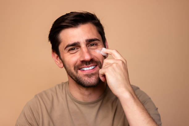 istock Man applying facial cream with a smile 2106255674