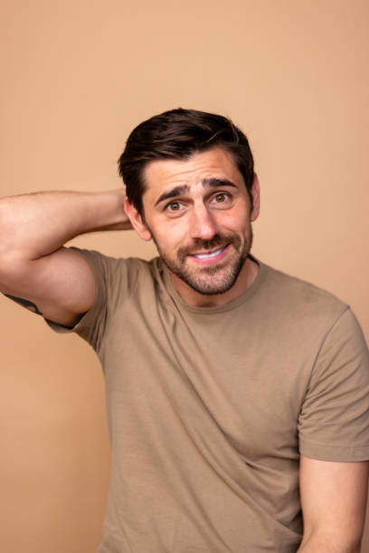 istock Confused man scratching head on beige background 2106258268
