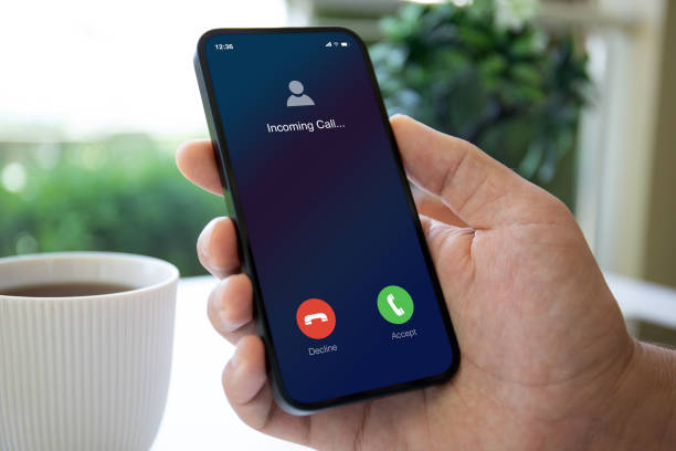 istock man hand holding phone with incoming call screen in cafe 2106261894