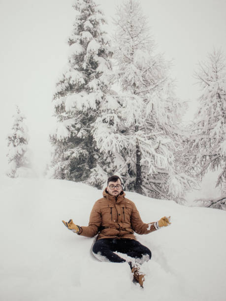 A man finds serenity and peace while meditating amidst the snow-covered landscape.