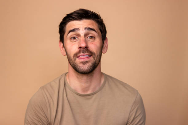 istock Confused young man on beige background 2106276877