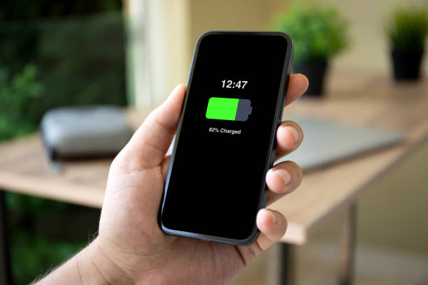 istock man hands holding phone with charged battery on screen 2106295518