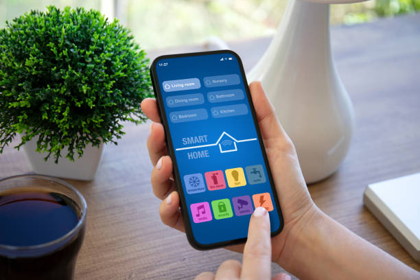 istock female hand hold  phone with smart home application apartment house 2106307900