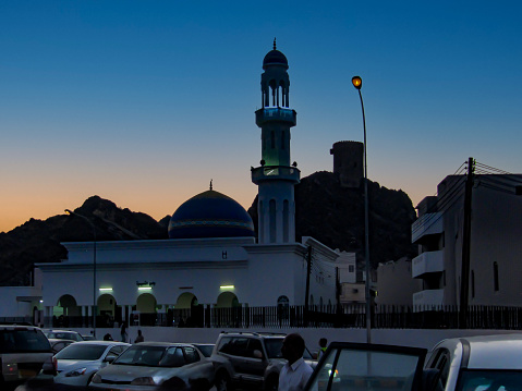 The watchtower of  the old souq (Mutrah Souq) and the Al-Darwaza Mosque in Muscat photographed at dusk, Oman