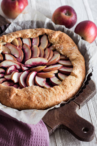 istock Sweet galette with apples and elder berries on wooden board. 2106319980