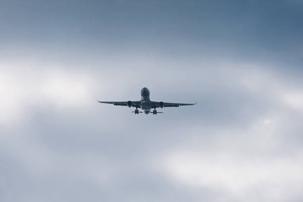 istock Airplane flying in sky with clouds 2106328269