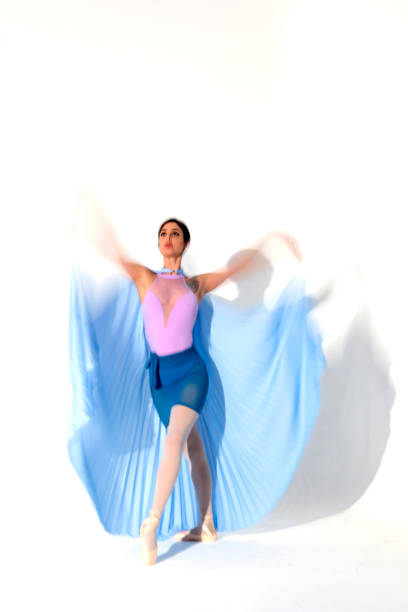 istock Young ballerina in blue skirt dances in studio light.Long exposure. White Background 2106334060