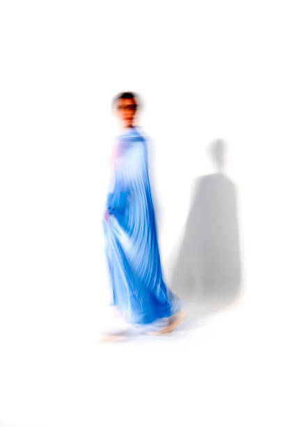 istock Young ballerina in blue skirt dances in studio light.Long exposure. White Background 2106346048