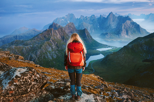 Woman backpacker hiking solo in Norway travel lifestyle female traveler in mountains of Lofoten islands tourist enjoying aerial view outdoor healthy lifestyle summer vacations adventure getaway