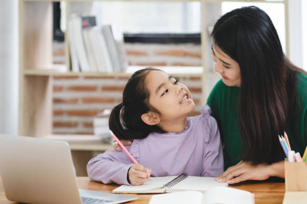 istock A woman is helping a young girl with her homework 2106444902