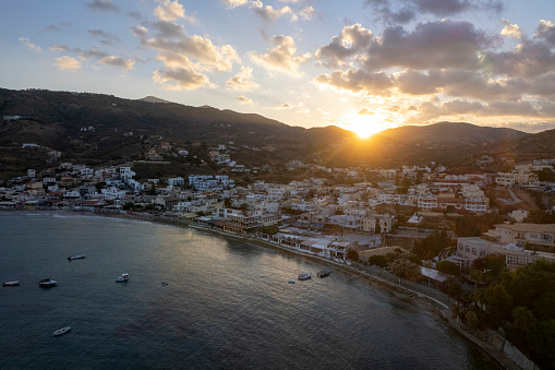 Aerial view of sunrise over calm bay and city in distance