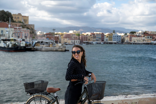 Woman pauses at harbour with bicycle