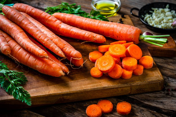 istock Freshly sliced organic carrots on cutting board 2106545963