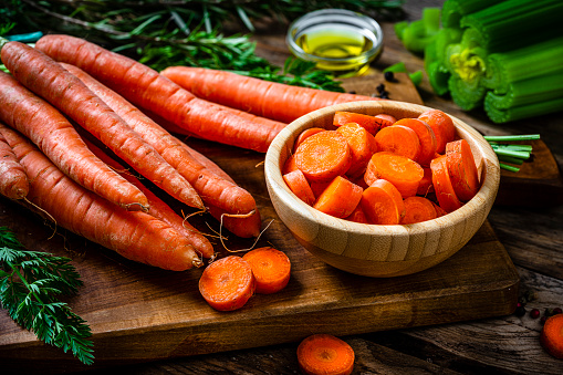 Freshly sliced organic carrots in a wooden bowl