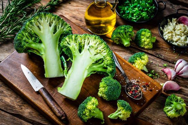 istock Freshly halved organic broccoli on wooden cutting board 2106546027