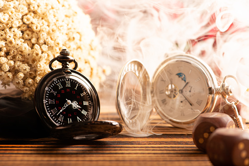 Antique clock and accessories, old and beautiful clock and accessories on rustic wood and dark background, selective focus.