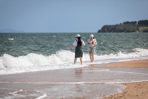 Women enjoying nature together on the beach. They are close friends, laughing, communicating, and strengthening their bond of friendship by the seaside