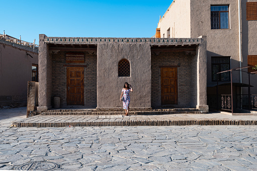 a lady poses in the streets of the old towm Khiva, Uzbekistan