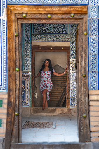 a lady poses  in the doorway of a madrassa, Khiva, Uzbekistan