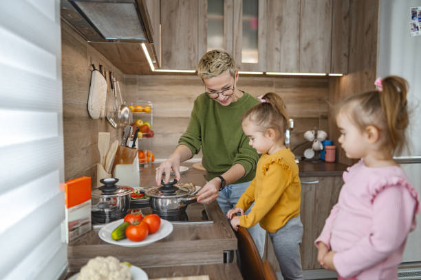 istock Mother and her daughters in the kitchen making rice for lunch on a stove top 2106617200
