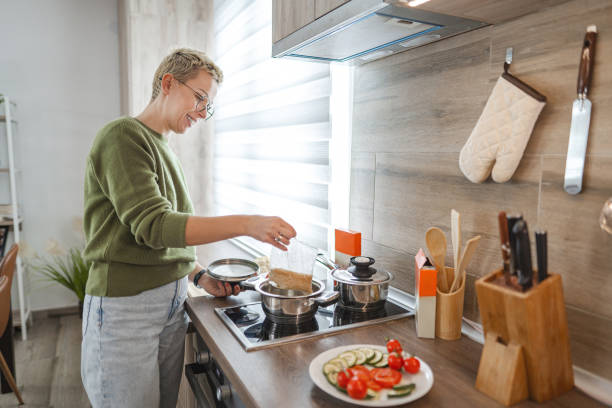 istock Woman boiling rice packet for lunch on stove top in the kitchen 2106631105