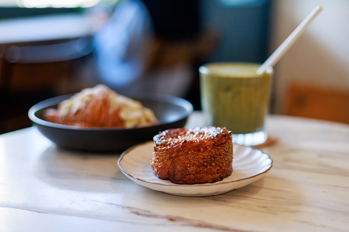 Sweet pastries and an iced matcha latte served on a table in a café.