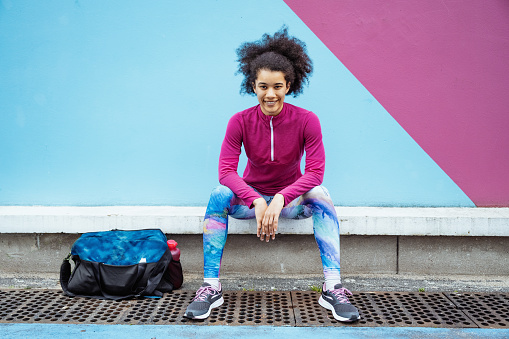 Female multiracial athlete exercising in the city. Full length model