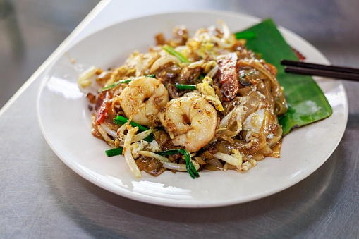 Wok-fried flat rice noodles with, egg, bean sprouts, prawns, soy sauce and chili paste. Popular Malaysia street food 