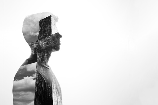 A double exposure silhouette of a man and a crucifix, Religious concept