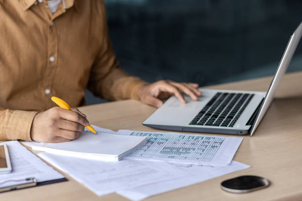 istock Focused indian businessman working at his office desk with laptop and documents 2106702308