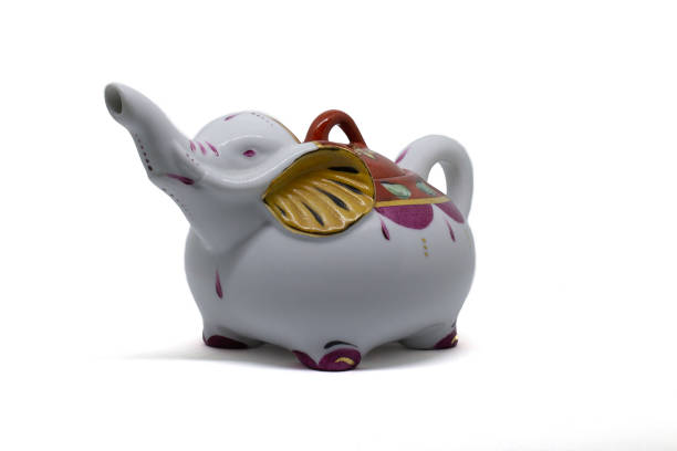 White vintage elephant teapot gold purple on white background