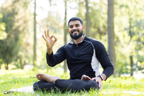 istock Man meditating peacefully in a lush green park 2106741375