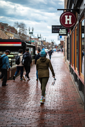 Cambridge, MA, USA - March 20, 2024: view of the iconic architecture of the famous Harvard University in Cambridge, Massachusetts, USA on a winter day with some locals and students passing by.